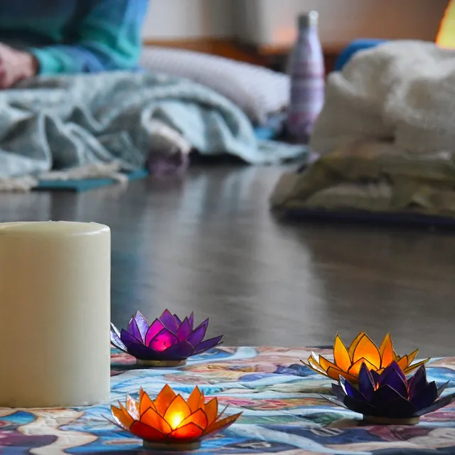 a candle and lotus flowers at the centre of the room