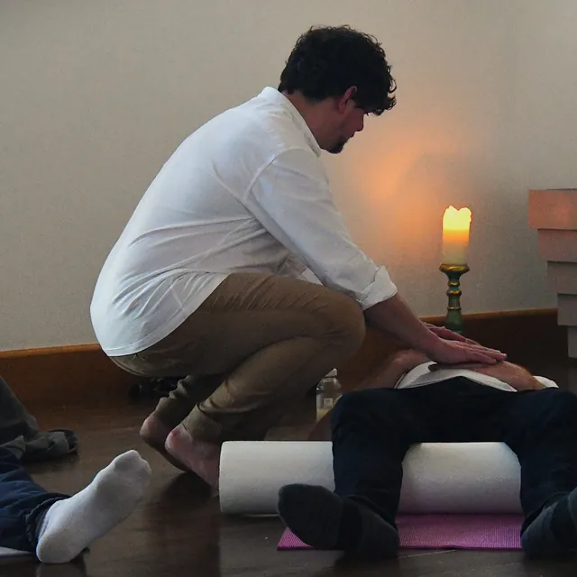 a guide kneeling beside someone by candlelight