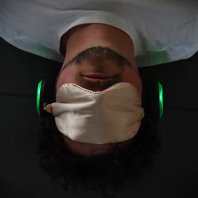 someone resting in an eye mask and headphones during a round