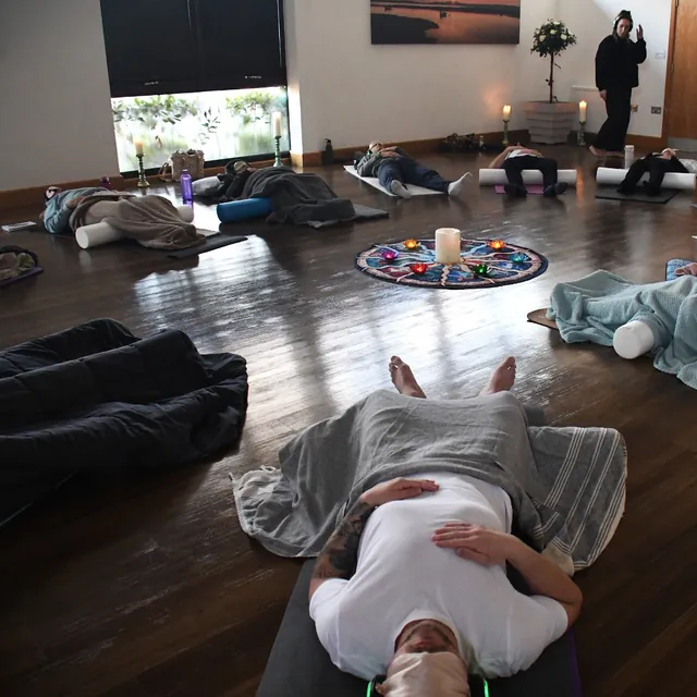 the room, with bodies resting on mats across the floor